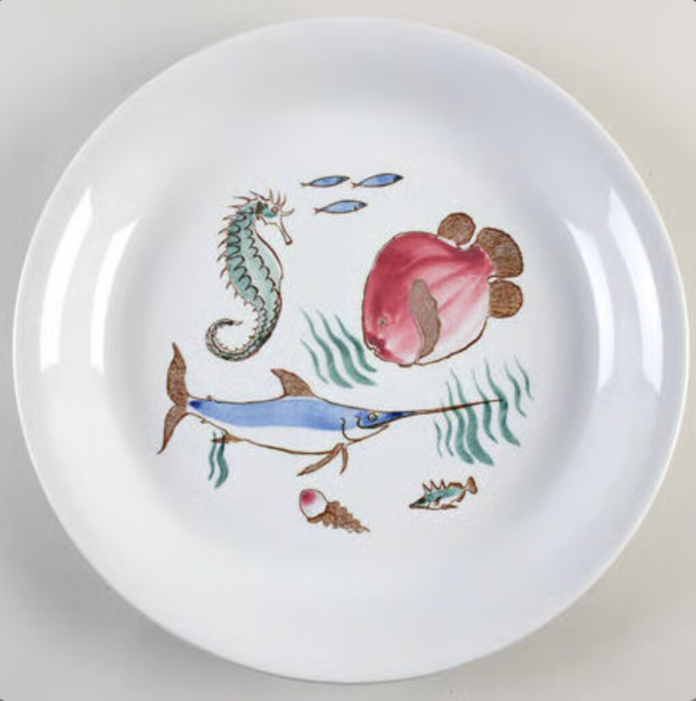 A plate with ocean animals and seaweed printed on it.